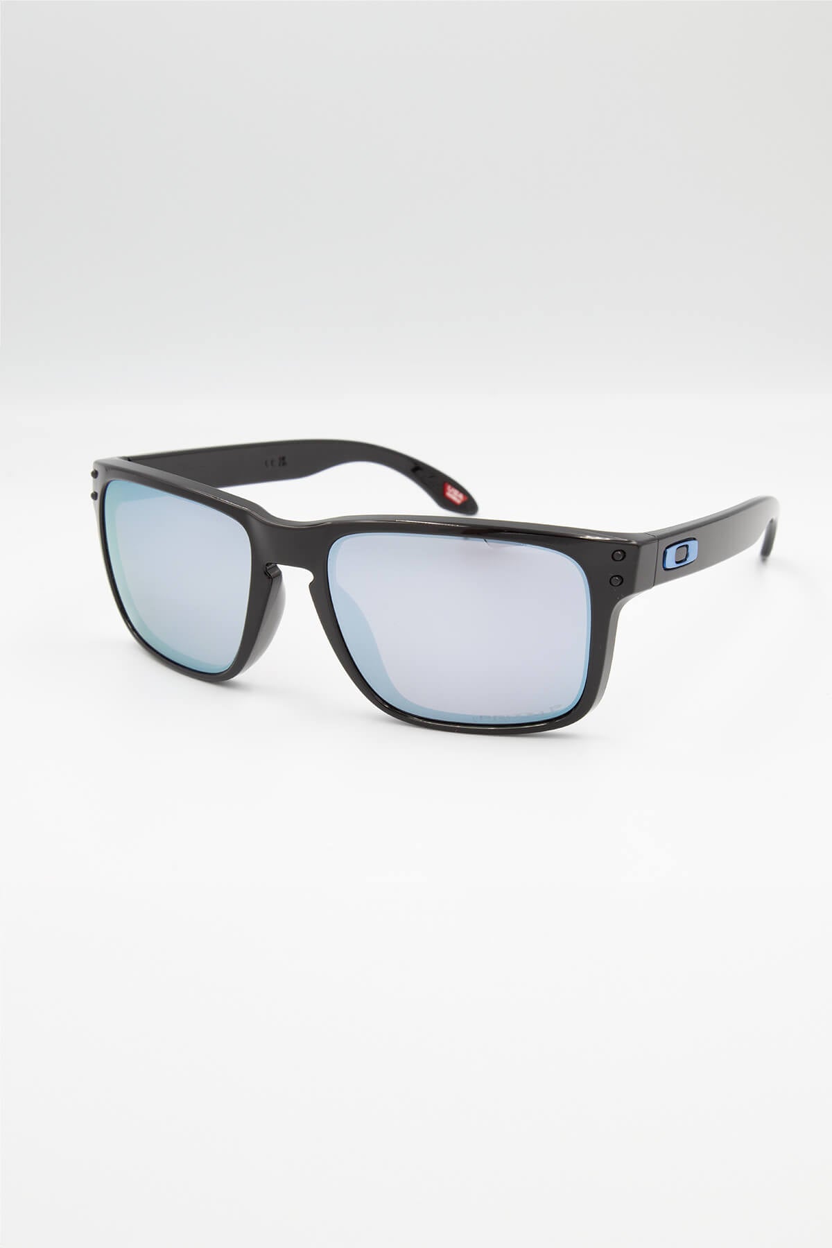 The Oakley Holbrook sunglasses feature a black lightweight O Matter frame, reflective lenses, and a small blue logo on the temple, displayed against a white background.