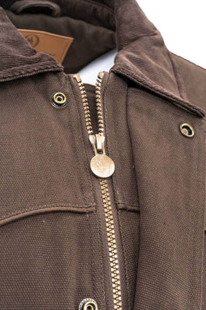 Close-up of the Outback Cattleman Jacket showcases a metal zipper partially zipped, featuring a circular design on the zipper pull. The jacket boasts multiple pockets with flap closures and brass snap buttons. The inner collar is lined with corduroy material, making it an ideal companion for outdoor adventures.
