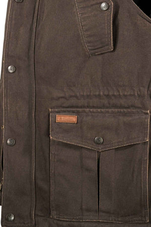 Close-up image of a brown, heavy-duty canvas jacket. The jacket features reinforced stitching, metal snap buttons, and a flap pocket with a small leather tag above it. The material appears rugged and durable, much like the Outback Cattleman Vest, which is designed for outdoor or heavy work use.