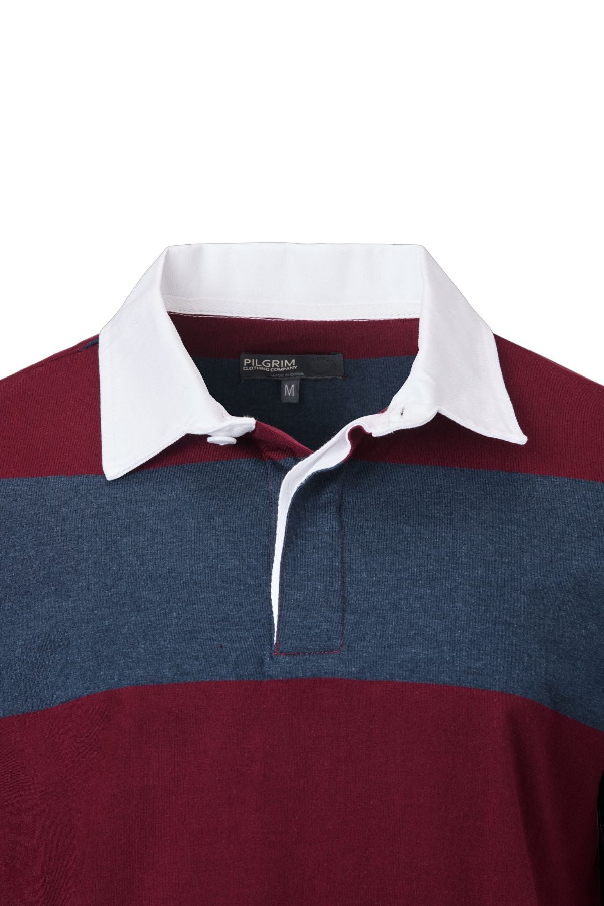 A close-up of the Pilgrim Rugby Top featuring a white collar, navy blue and burgundy stripes, button placket, and visible "PILGRIM" brand label with size "M" inside the collar—classic vintage sportswear style.