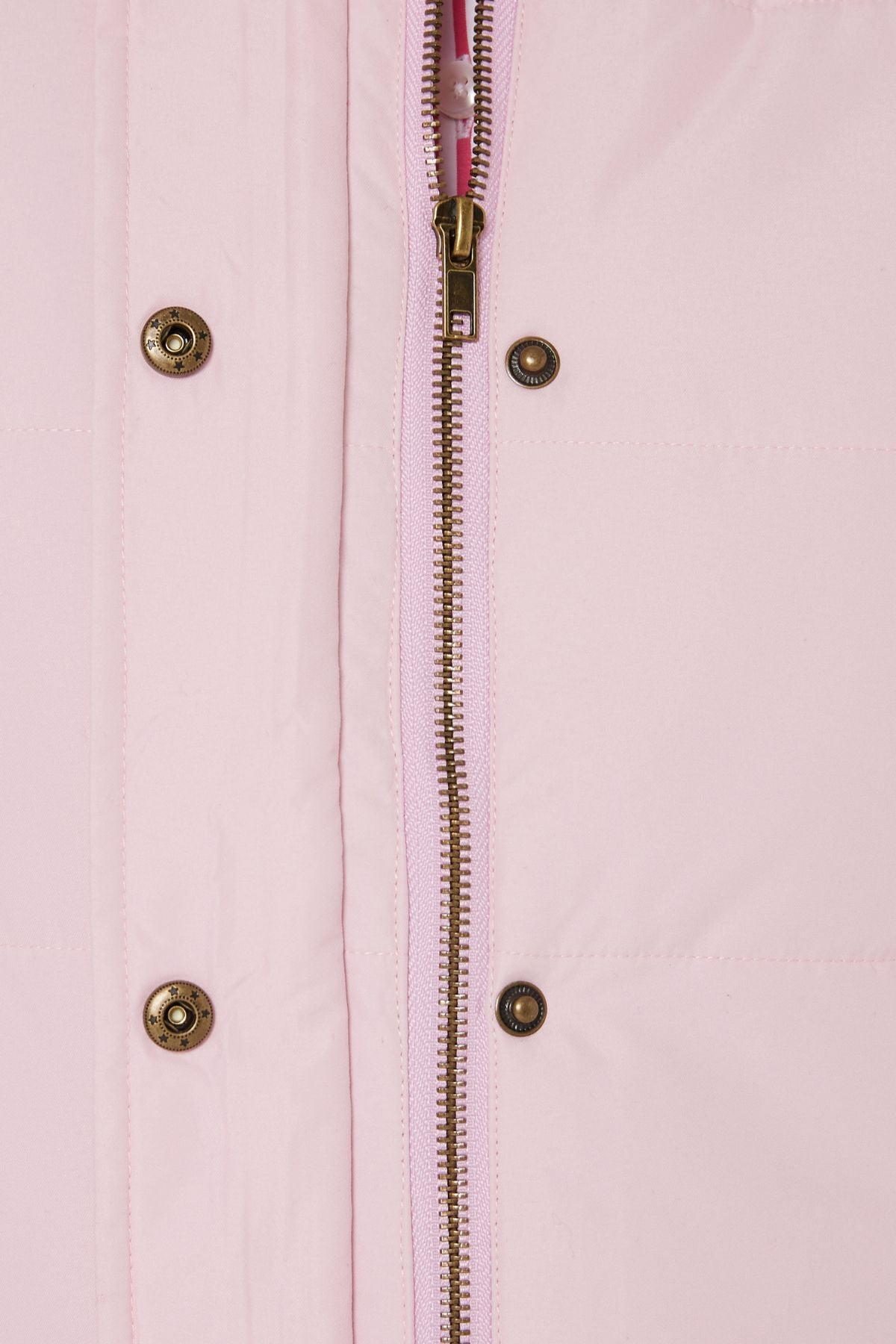 Close-up of the Pilbara Ladies Vest, a light pink quilted design with Polyfill padding, silver zipper, and metallic snap buttons.