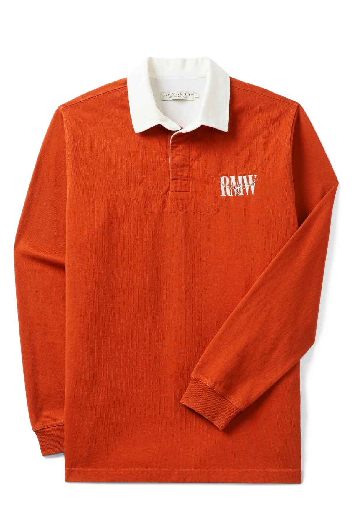The RM Williams Steers Head Rugby is an orange long-sleeve jersey crafted from organic cotton, with a white collar and cuffs. It features a partial button placket and the RM Williams logo embroidered on the left chest.