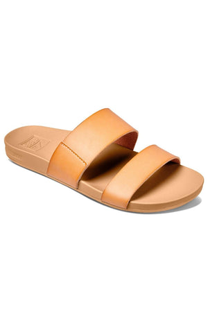 The REEF Cushion Vista sandal in tan features two wide vegan leather straps across the top and a flat sole. Its minimalistic design includes a cushion bounce midsole for enhanced comfort, and the slightly contoured footbed provides extra support.