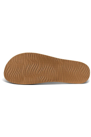 Image of a brown shoe sole with wavy tread patterns, resembling REEF Cushion Vista Perforated sandals. The edges are smooth and the surface is textured with curved lines, offering excellent grip and enhanced arch support for comfort.