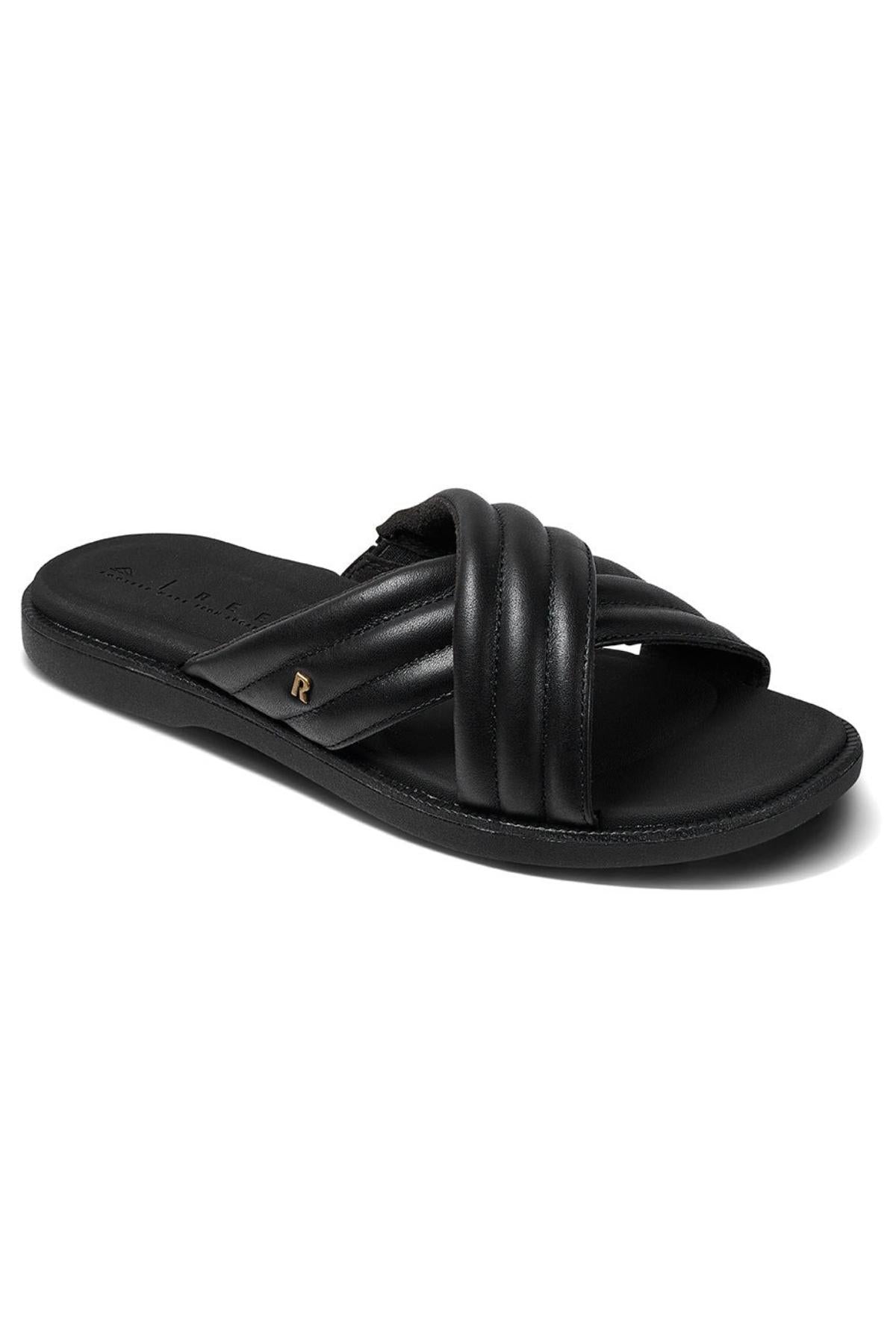 The REEF Lofty Lux X is a black slip-on sandal with padded crisscross straps, a flat sole for comfort, and a subtle metallic accent on the side.