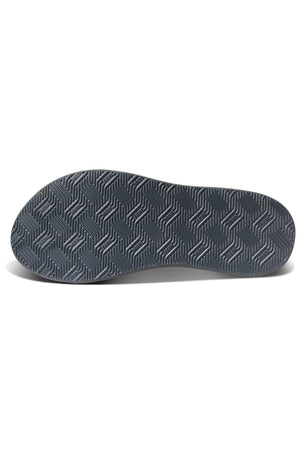 The image depicts the sole of the REEF Phantom Nias shoe. The bottom features a dark gray outsole with a textured pattern of interlocking chevron shapes arranged in a zigzag design, ensuring durability.