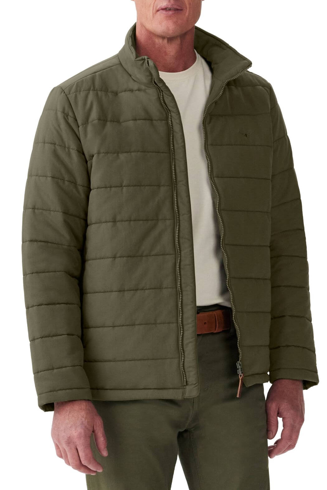 A person is wearing a durable polyester twill olive Patterson Creek Jacket by RM Williams with matching pants. The quilted puffer jacket, slightly open to reveal a white T-shirt underneath, stands out against the plain white background.