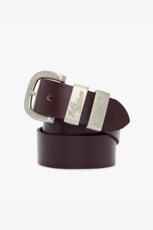 The RM Williams 1 1/2 3 Piece Solid Hide Belt is a dark brown belt crafted from solid hide leather, featuring a brushed nickel buckle with intricate engraved designs and text. The belt is rolled up, showcasing part of the buckle which displays an elegant eagle motif alongside the words "RRL & Co." It boasts a smooth, polished finish and is proudly made in Australia.