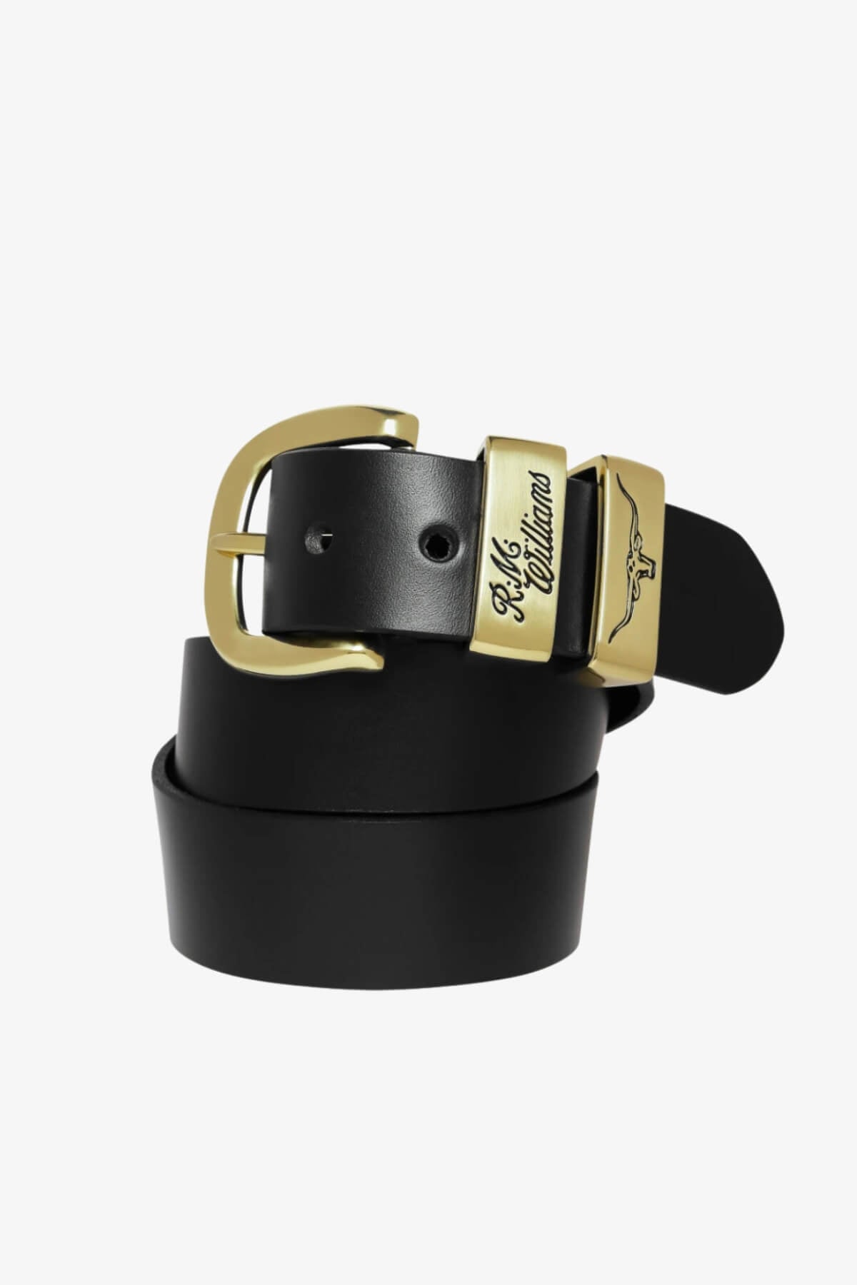 The RM Williams Drover Belt, made from black solid hide leather, features a classic brass buckle and gold loops—one engraved, one with a longhorn image. The belt is shown coiled on a plain white background.