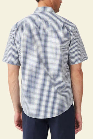 A man is shown from the back wearing the RM Williams Augusta Poplin Short Sleeve Shirt in a relaxed fit, blue and white check pattern, paired with dark pants against a plain, light-colored background.