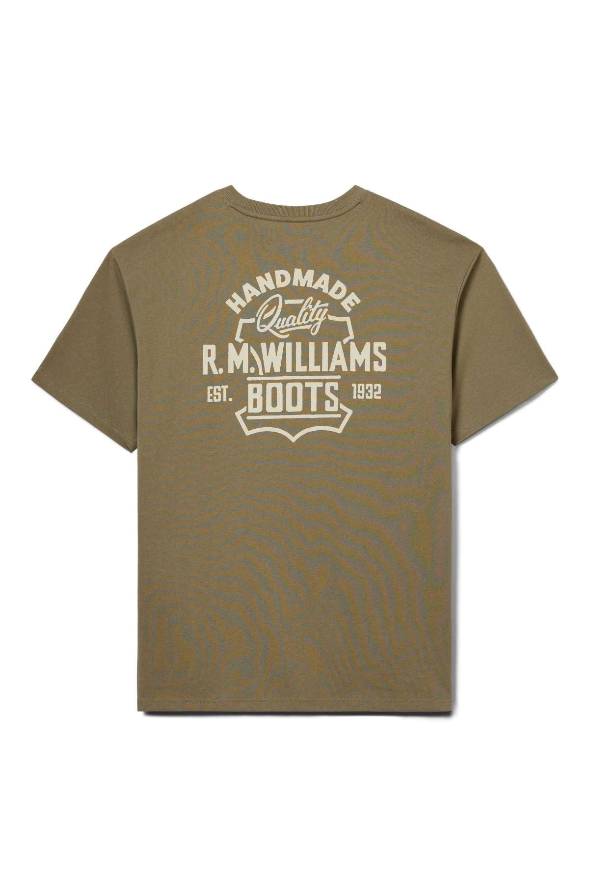 The RM Williams Boot T-Shirt is a khaki short-sleeve tee featuring a bold, vintage-style white graphic on the back that reads "Handmade Quality R.M. Williams Boots Est. 1932.