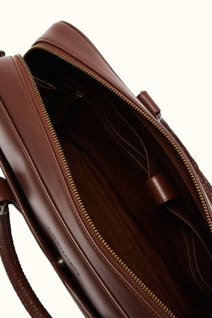 Close-up of an open RM Williams Briefcase made from full grain leather, featuring a visible zippered section and sturdy handles. The interior offers compartments with a smooth finish, while the exterior showcases this men's accessory's sophisticated design and texture.