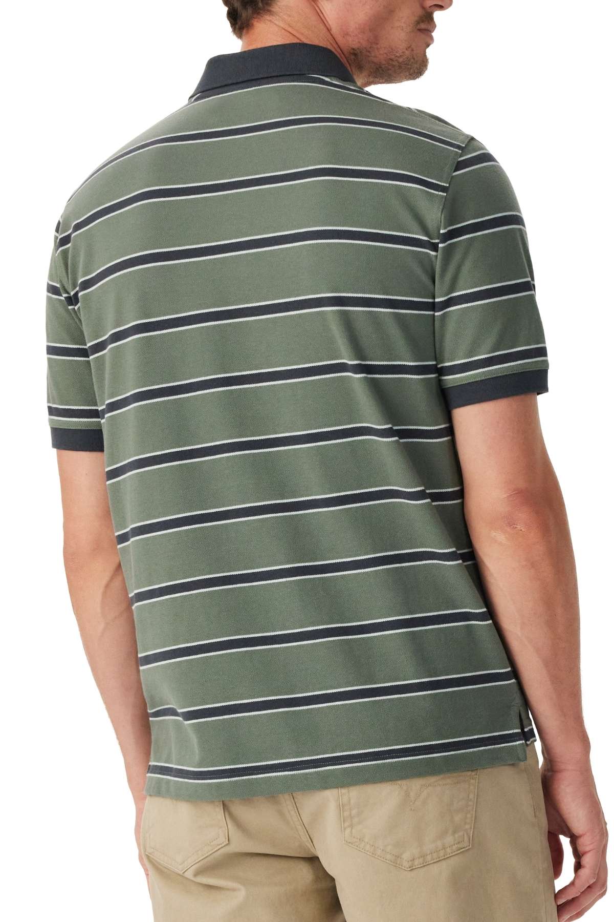 A man wearing the RM Williams Brunswick Stripe Polo with short sleeves and green, white, and navy stripes stands with his back to the camera, paired with khaki pants.