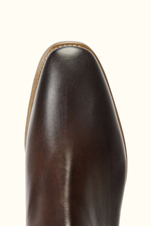 Close-up of the rounded toe of the RM Williams Burnished Comfort Craftsman Boot in polished brown leather with a stitched welt and smooth finish, set against a light background. Made in Australia.