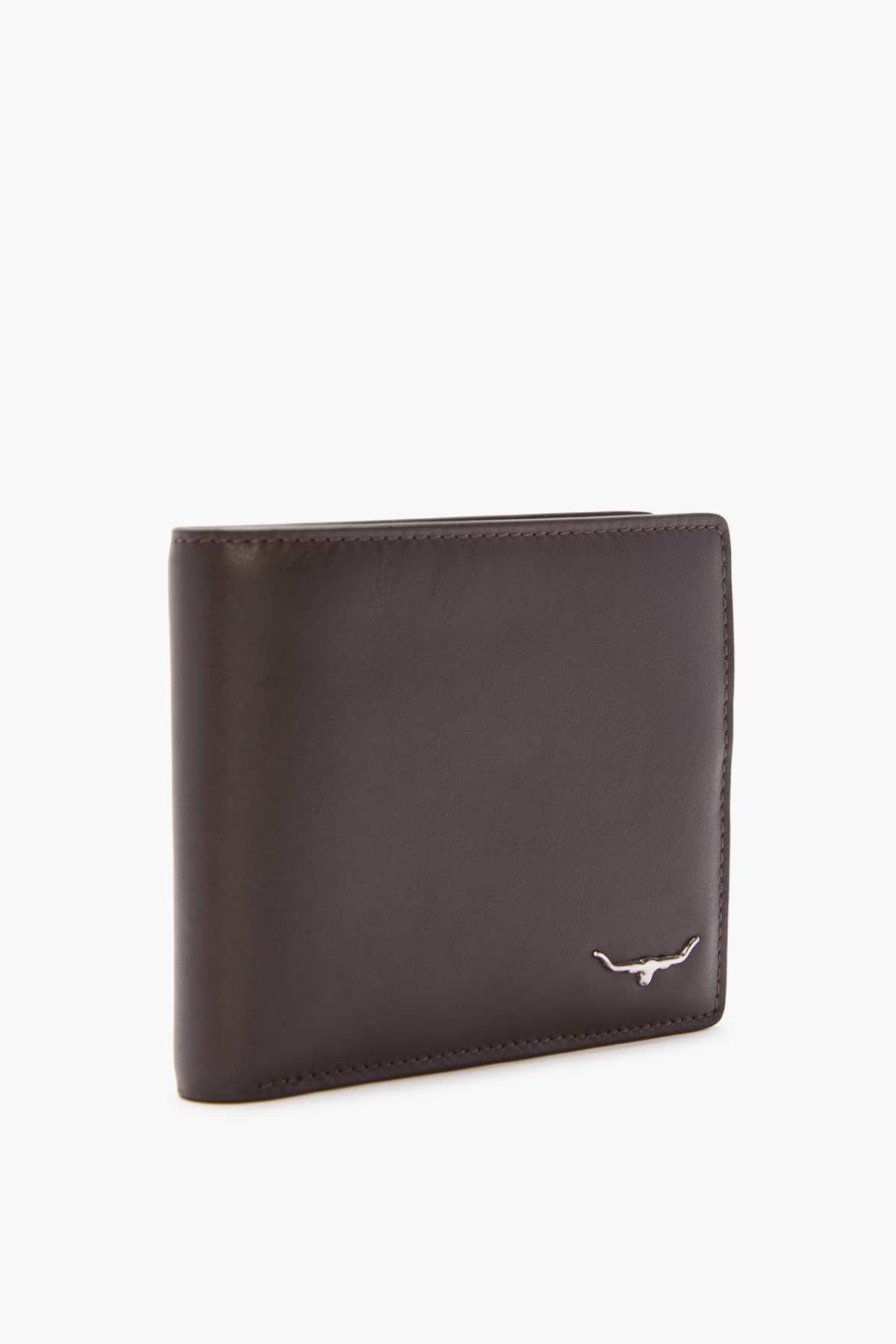 The RM Williams City Slim Bi-Fold, crafted from full grain brown leather and adorned with a small metallic bull emblem in the corner, stands upright against a plain white background. Its elegant design features multiple card slots for convenience.