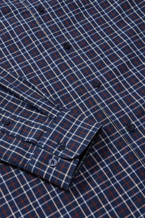 A close-up view of the RM Williams Classic Shirt, a blue and red checkered long-sleeve regular fit shirt, featuring dark blue buttons and a neatly folded sleeve. Made from organic cotton, the pattern consists of intersecting lines forming squares, perfect for a smart casual look.
