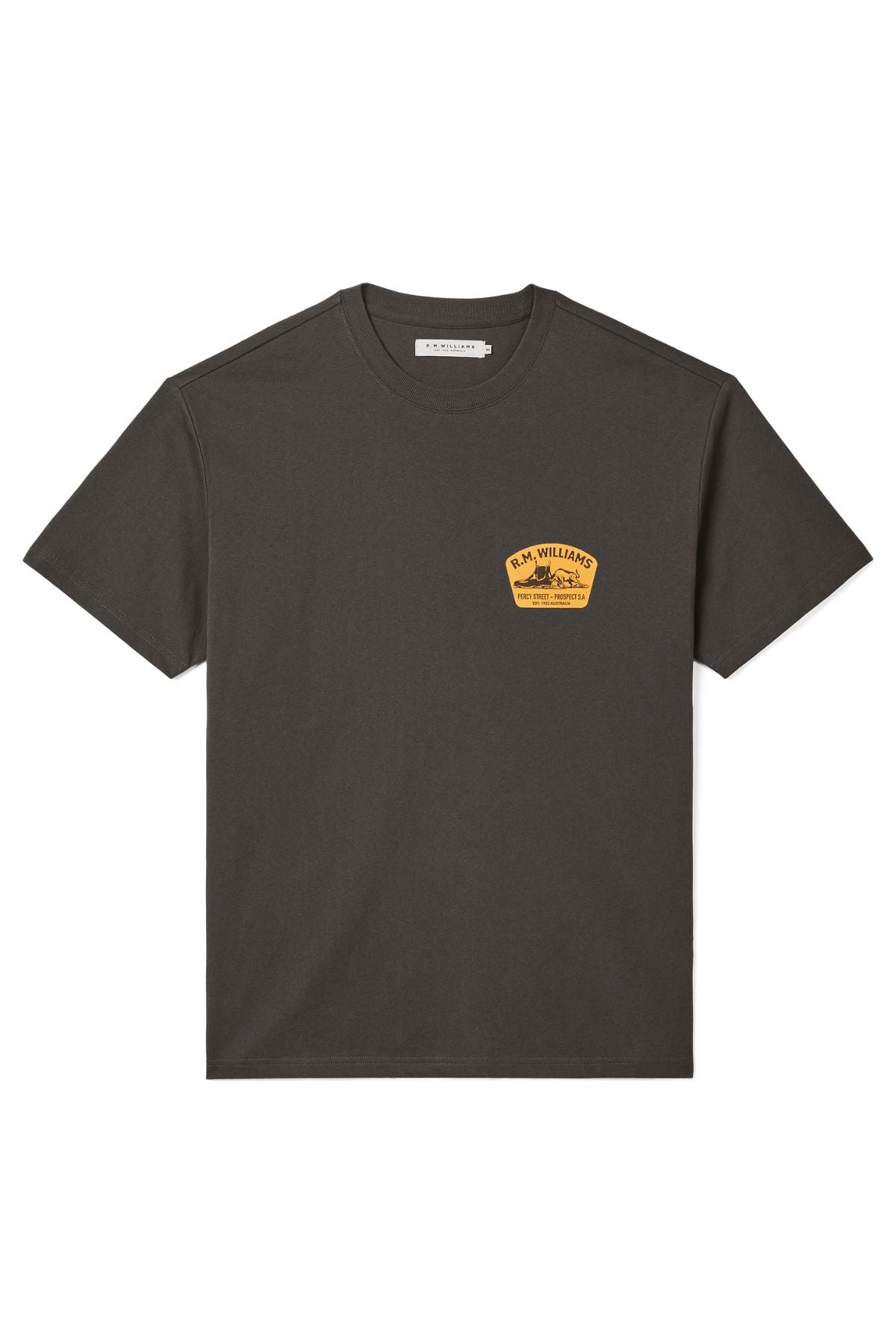 The RM Williams Craftsman T-Shirt is a black short-sleeve tee with a branded yellow patch on the upper left chest, featuring "R.M. Williams," additional small text, and unique artwork.