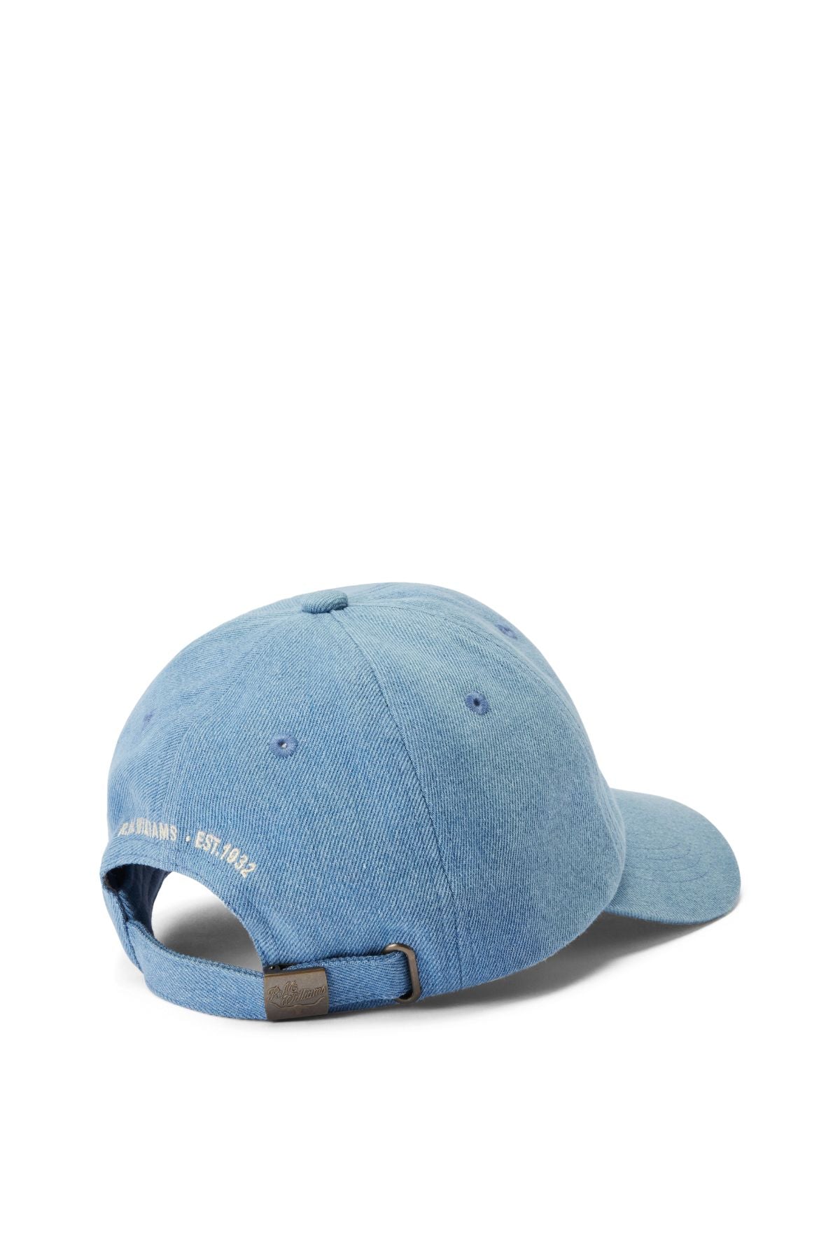 The RM Williams Cursive Twill Cap, in light blue organic cotton, features an adjustable strap with a metal clasp and small white embroidered text at the back for comfort and classic style.