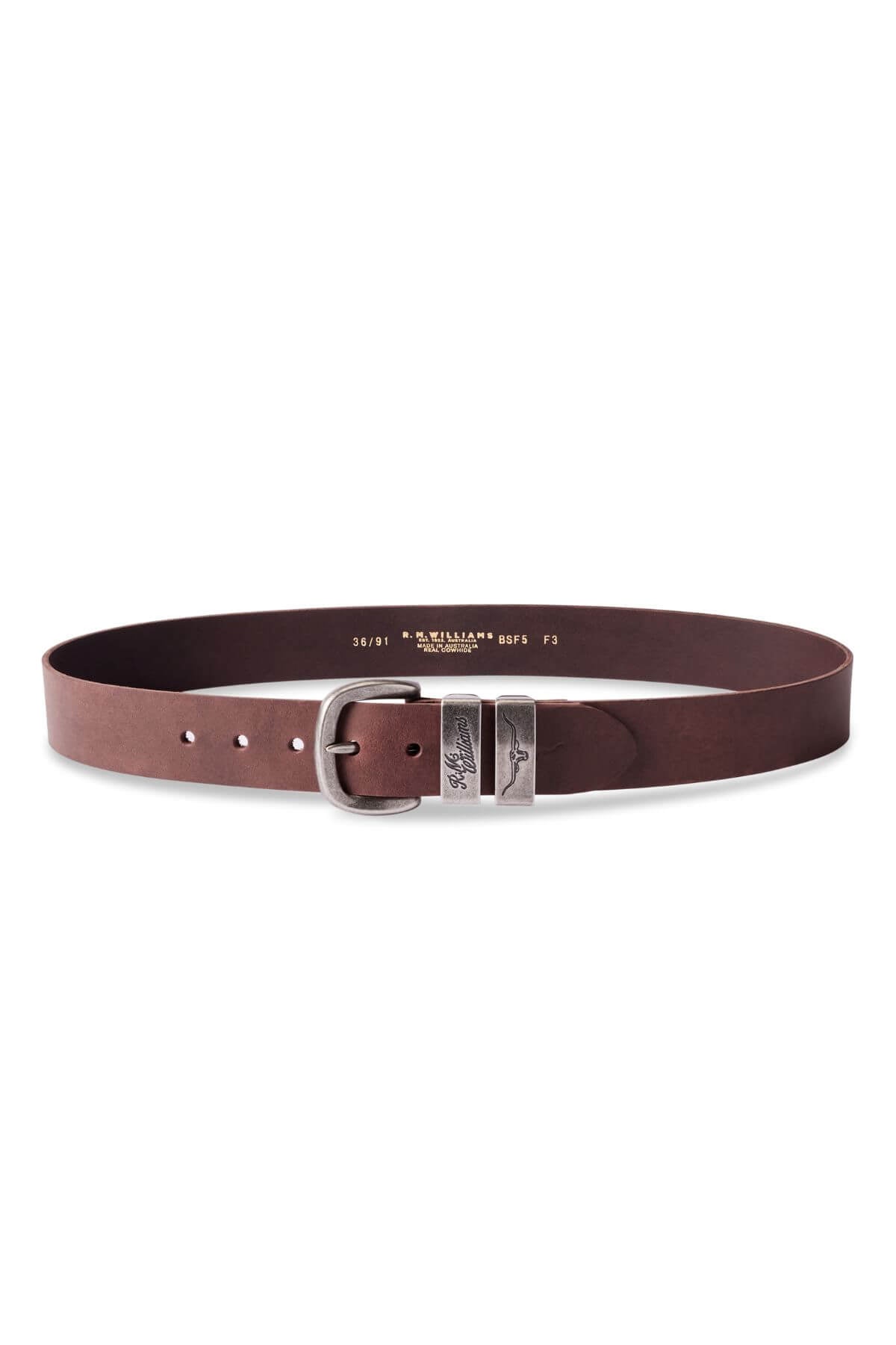 The RM Williams Drover Belt, a brown, handmade leather belt from Australia, is displayed against a white background. It features visible stitching and a silver rectangular buckle with a subtle engraved design. Made from Italian oiled nubuck leather, the belt offers multiple holes for adjustable sizing.