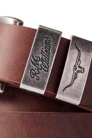 Close-up of the RM Williams Drover Belt made from brown Crazy Horse Leather, featuring two silver belt loops. One loop is engraved with the text "R.M. Williams," while the other displays an embossed image of a longhorn steer, highlighting the craftsmanship handmade in Australia.