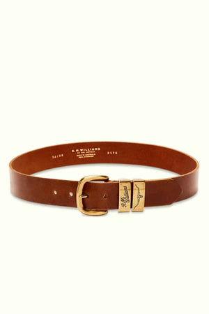 The RM Williams Drover Belt, crafted from brown pull-up leather and featuring a gold buckle, is displayed against a light background. The belt includes engraved text near the buckle that showcases the brand logo and size information. Made in Australia, it also has additional printed text on the interior detailing the brand and size.