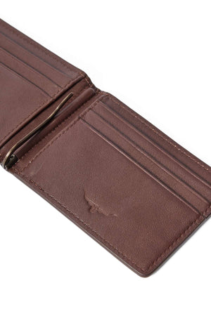 The RM Williams Farrier Bi Fold Clip Wallet is an open brown leather wallet with multiple card slots, a metal money clip, and an embossed bull logo on the inside pocket.