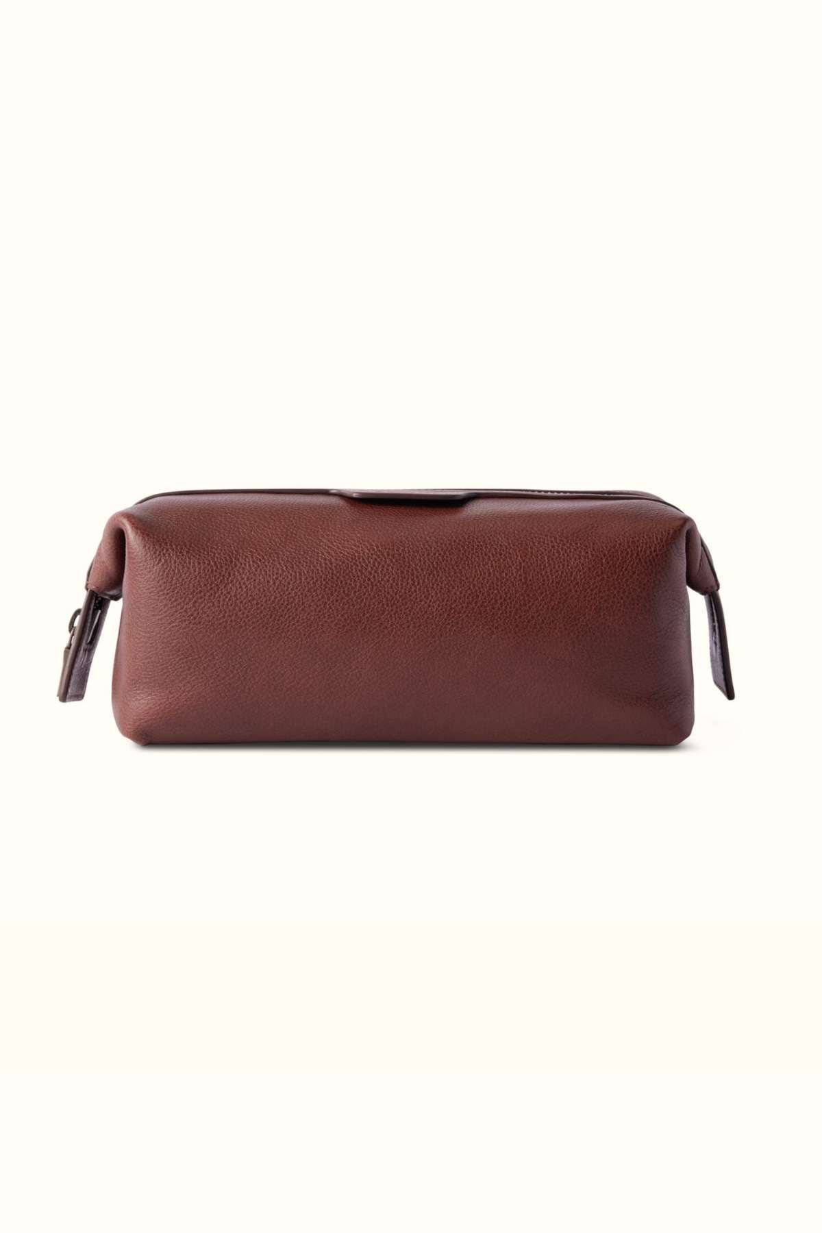 The RM Williams Farrier Washbag is a rectangular brown leather bag featuring a frog-mouth zipper on top and small leather pull tabs at each end, shown against a plain white background.