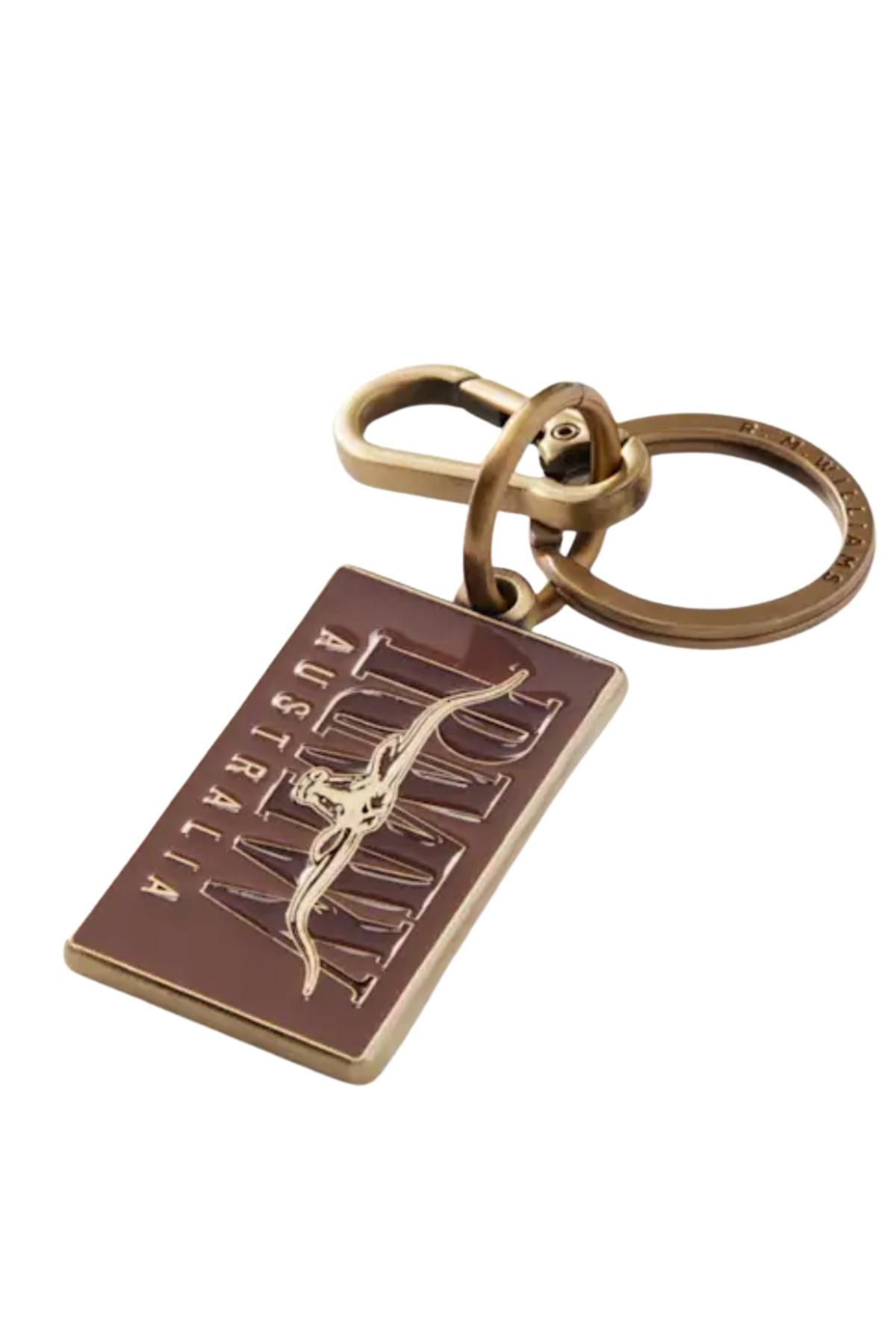 The RM Williams Heritage Logo Enamel Key Ring is a rectangular bronze keychain featuring "AUSTRALIA" and a kangaroo outline, attached to a round brass hardware keyring.