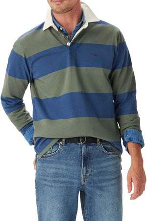 A man wears the RM Williams Jones Stripe Rugby with a twill collar over a denim shirt, blue jeans, and a black belt. His hands are in his pockets and his head is partly out of frame.