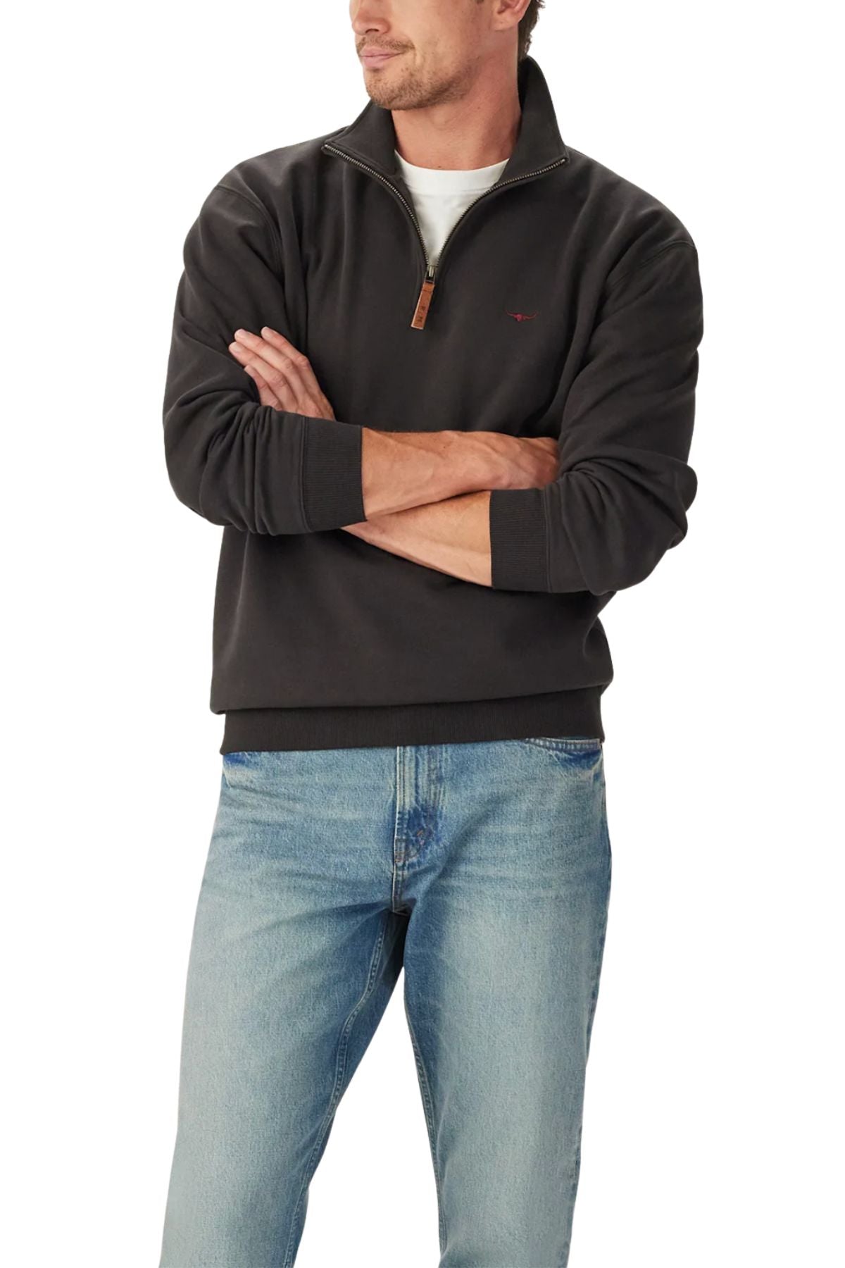 A man stands with arms crossed, wearing the RM Williams Mulyungarie 1/4 Zip Sweatshirt in black over a white shirt and light blue jeans against a plain white background.