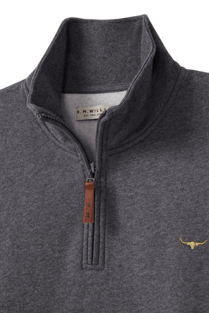 The RM Williams Mulyungarie Fleece is a charcoal gray quarter-zip sweatshirt with a brown leather zipper pull, a small yellow longhorn logo on the chest, and an R.M. Williams label inside the collar.