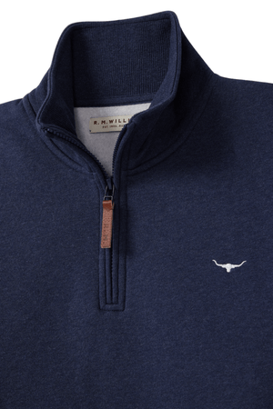 The RM Williams Mulyungarie Fleece is a navy blue quarter-zip sweatshirt crafted from brushed cotton fleece, featuring a brown leather zipper pull and an embroidered bull's head logo on the left chest. The inner tag displays "R.M. Williams.