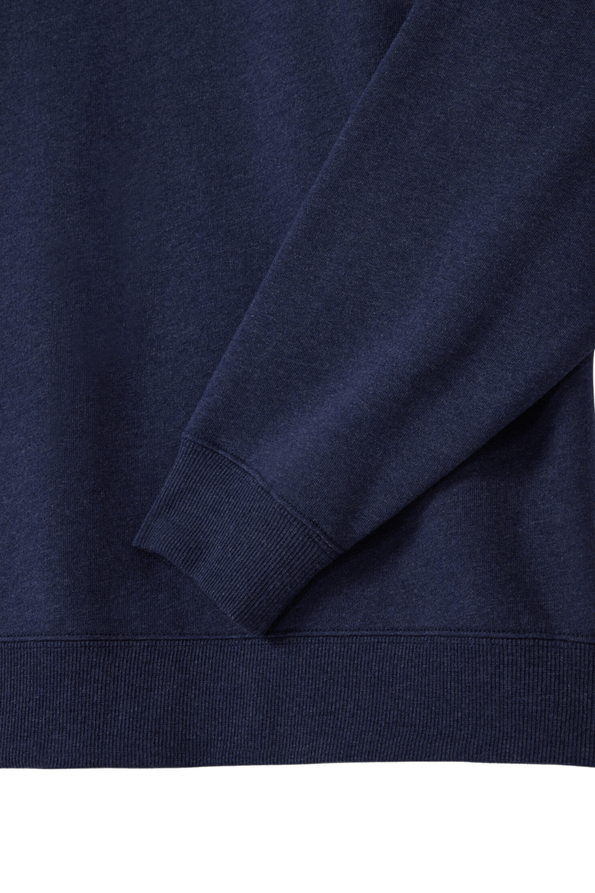Close-up of the RM Williams Mulyungarie Fleece navy blue quarter-zip sweatshirt, highlighting its right sleeve and a section of the body. The fabric looks soft and slightly textured, featuring ribbed cuffs and hem.