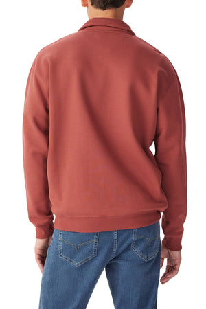 Someone is shown from the back against a white background, wearing blue jeans and the rust-colored RM Williams Mulyungarie Fleece, a relaxed fit quarter zip sweatshirt.