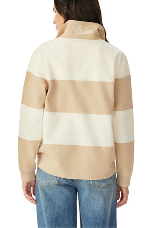 Woman shown from the back wearing the RM Williams Narran 4 Panel Rugby, a beige and white striped jacket with "R.M. Williams" embroidered on the collar, paired with blue jeans.