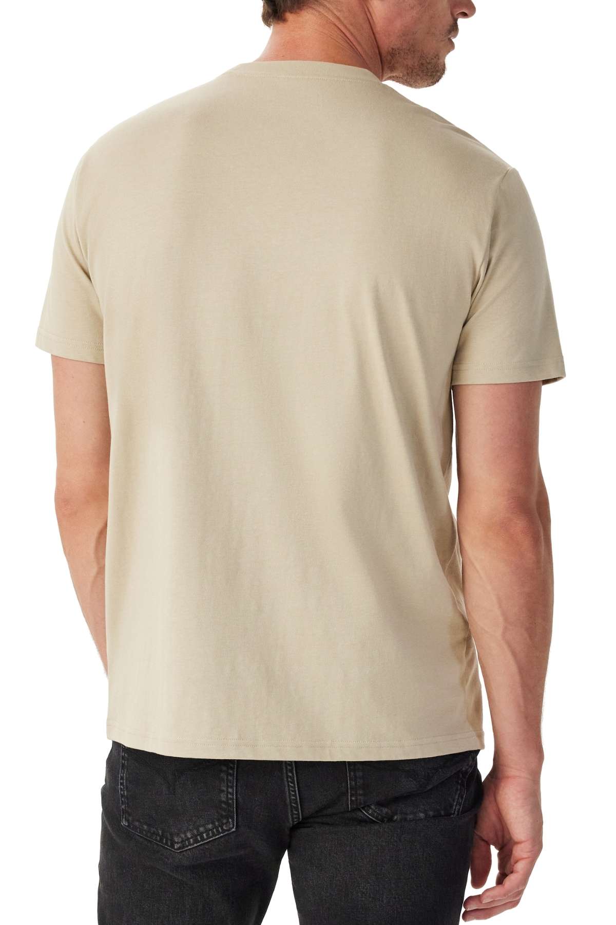 A man is shown from the back wearing a plain beige RM Williams Parson T-Shirt with black jeans against a white background.