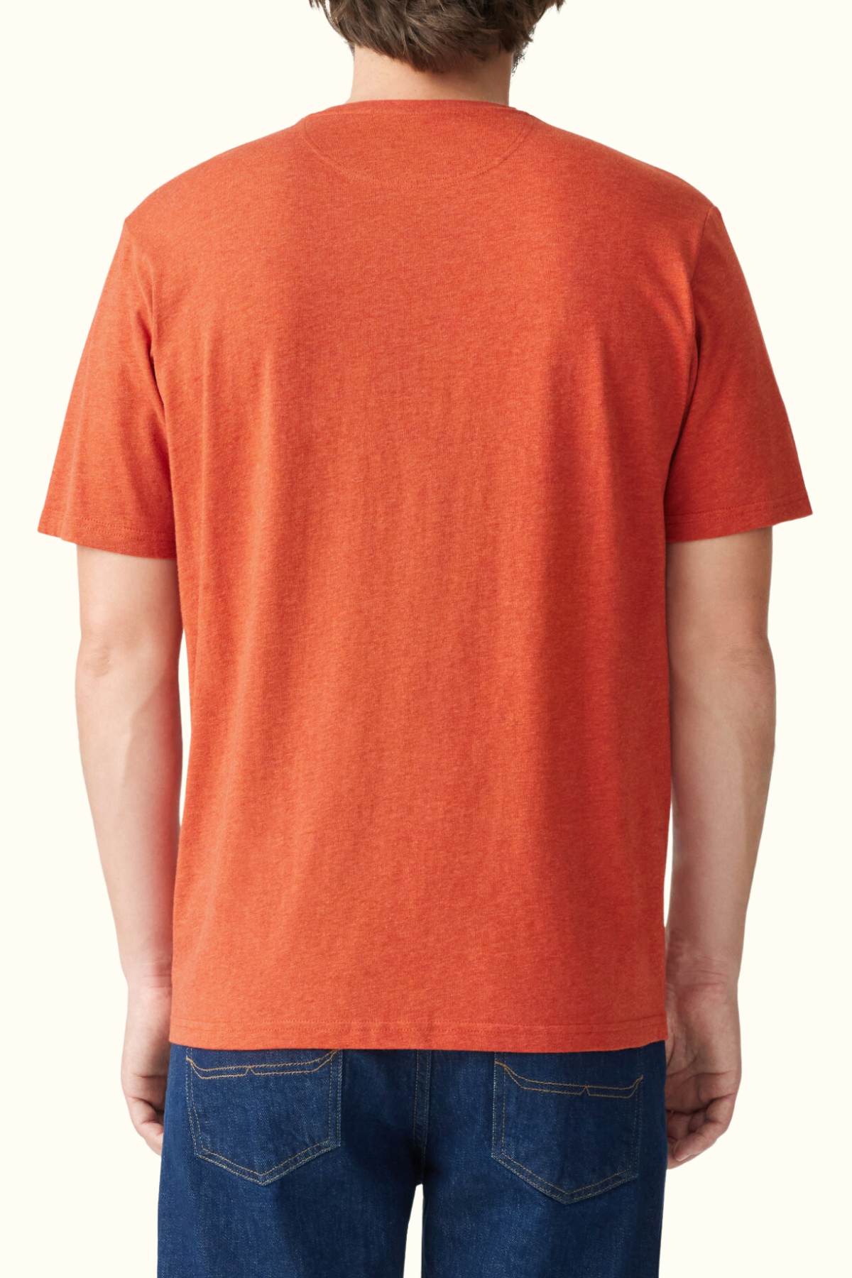 Rear view of a person wearing an RM Williams Parson T-Shirt in orange, paired with blue jeans. The image showcases the cotton T-shirt from the back against a neutral background.