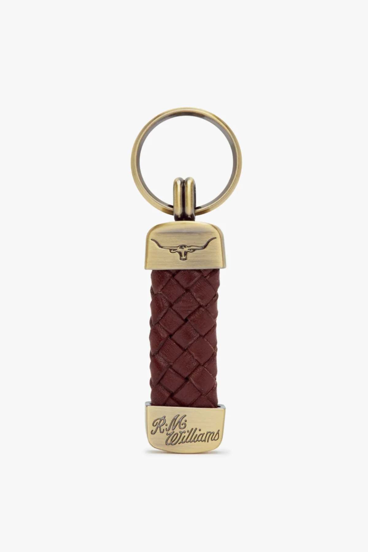 The RM Williams Plaited Key Ring features a brass loop, braided dark brown kangaroo leather center, engraved bull logo at the top, brass-toned fittings, and “R.M. Williams” script at the bottom. Made in Australia.