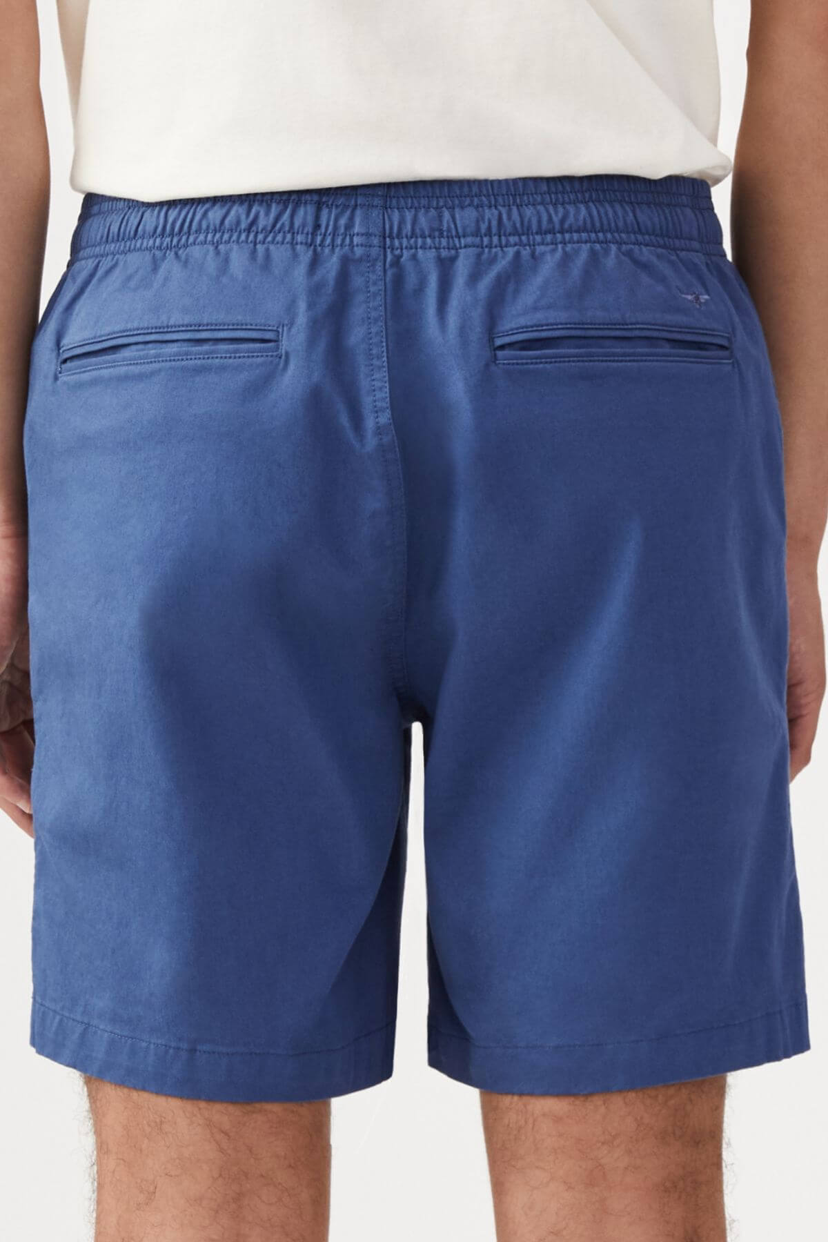 A person is shown from the back wearing the RM Williams R.M.W Rugby Short in blue stretch cotton twill, featuring an elastic waistband and two horizontal back pockets for a relaxed style.