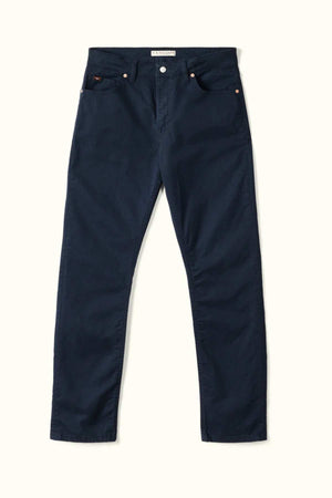 The RM Williams Ramco 5 Pocket Jeans in dark blue, made from stretch cotton twill with a classic five-pocket design, are shown laid flat on a light background.
