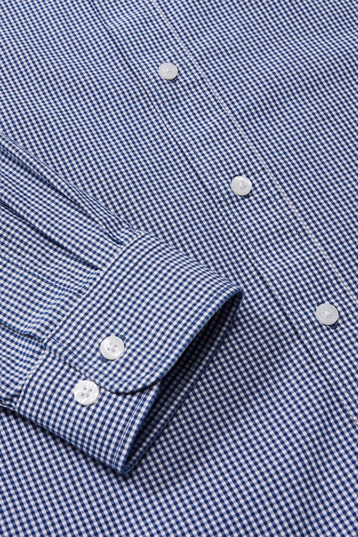 Close-up of the RM Williams Classic Shirt in a blue and white micro gingham check, highlighting its regular fit. The cuff is detailed with two buttons, accompanied by white buttons down the front, displaying sequential button details.