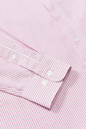 A close-up of the RM Williams Regular Shirt, a slim fit long-sleeve dress shirt with thin pink and white vertical stripes, made from organic cotton and detailed with white buttons on the cuff and front.