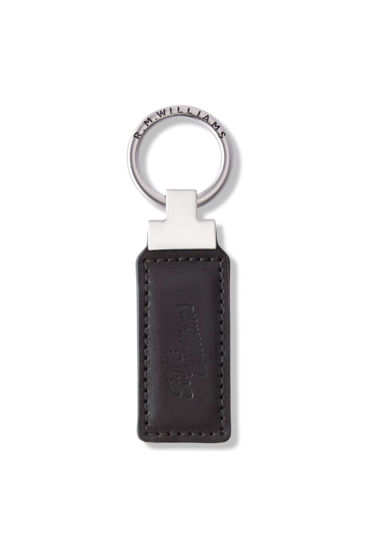 The RM Williams Ridgewood Key Fob is a sleek, durable leather accessory featuring a metallic ring engraved with "R.M.Williams." It has a rectangular black leather fob with edge stitching and an embossed script logo, combining simplicity and elegance.