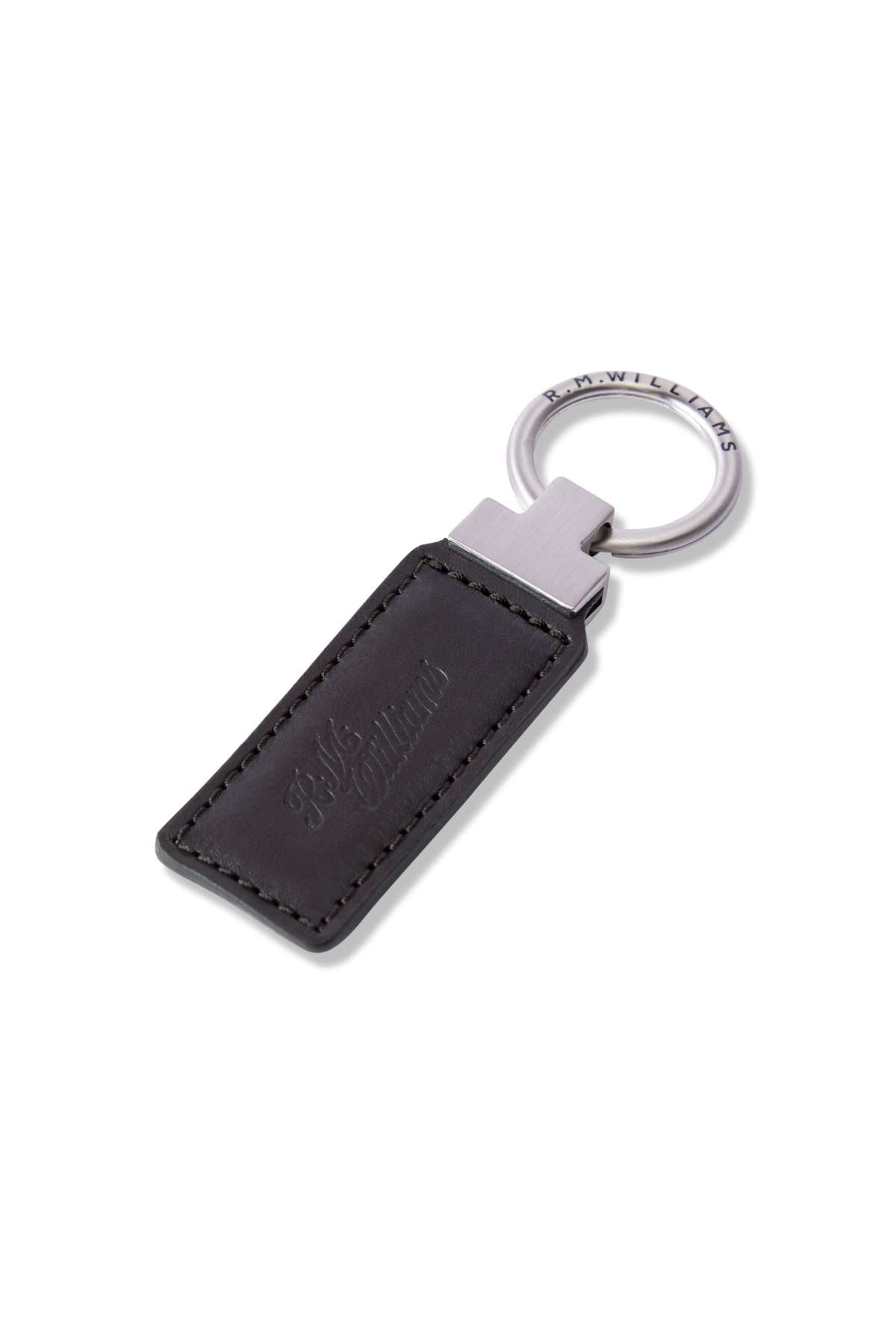 The RM Williams Ridgewood Key Fob is a robust leather accessory with a black rectangular design, stitched edges, and an embossed script logo. It's elegantly attached to a silver metal ring featuring engraved writing for extra sophistication.