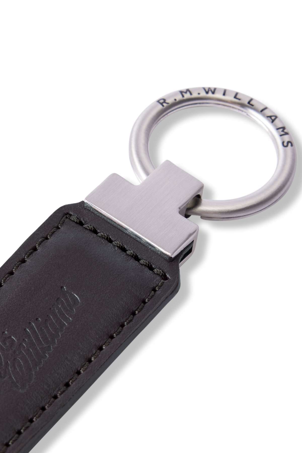 Close-up of the RM Williams Ridgewood Key Fob in durable leather, featuring a metal ring engraved with "R.M. WILLIAMS." The stitched leather is embossed with a script logo, showcasing the seamless connection between the leather and metal.