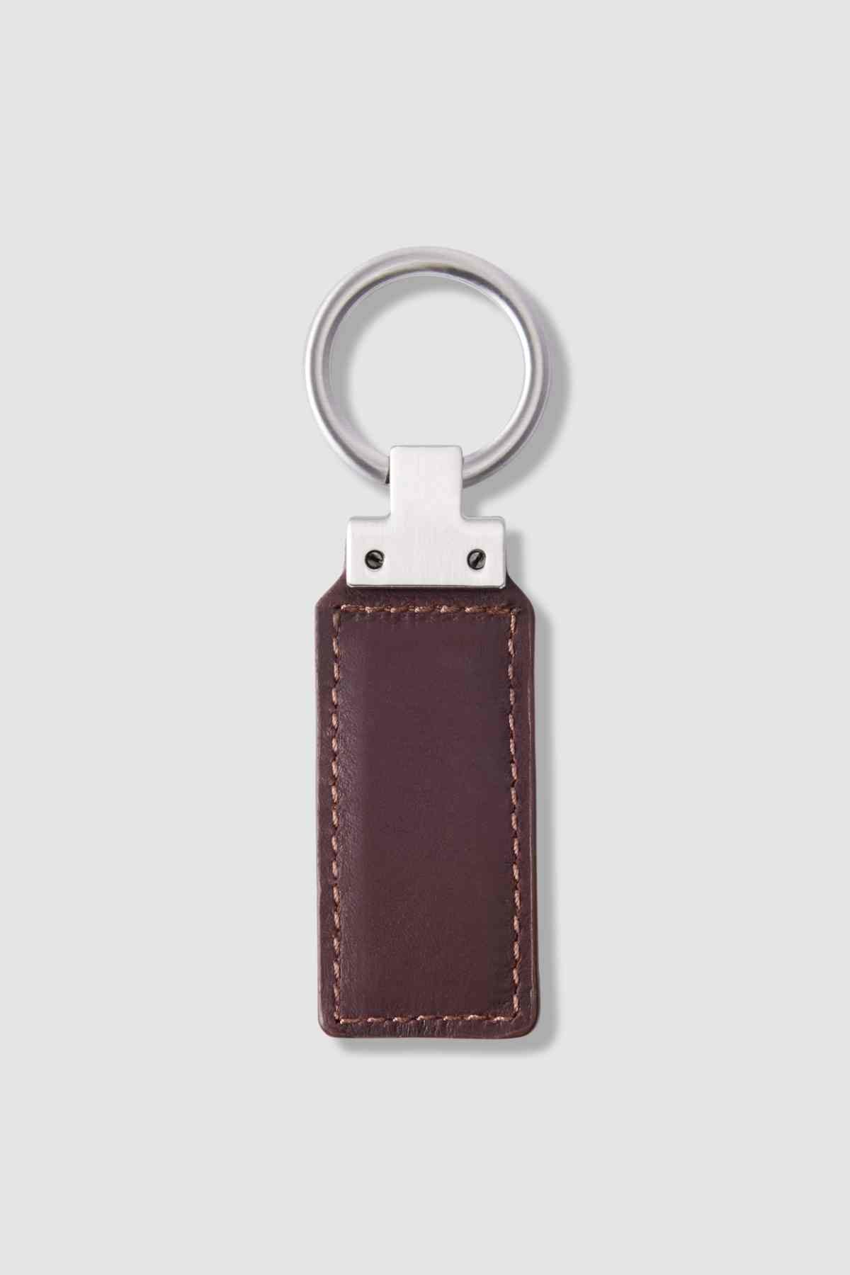 A rectangular brown leather RM Williams Ridgewood Key Fob with visible stitching and a silver metal ring, shown on a light gray background.