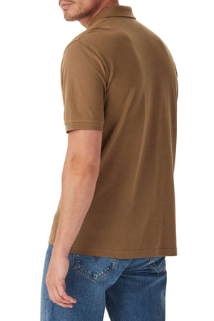 A man is shown from the back, turning slightly to his left against a white background, wearing the RM Williams Rod Polo in brown and blue jeans.