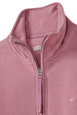 A close-up of the pink RM Williams Trickett Zip Neck Sweatshirt features a high collar, small longhorn embroidery on the chest, and a partially open zipper showing an "R.M.W." label. It highlights its premium loop back cotton terry fabric.