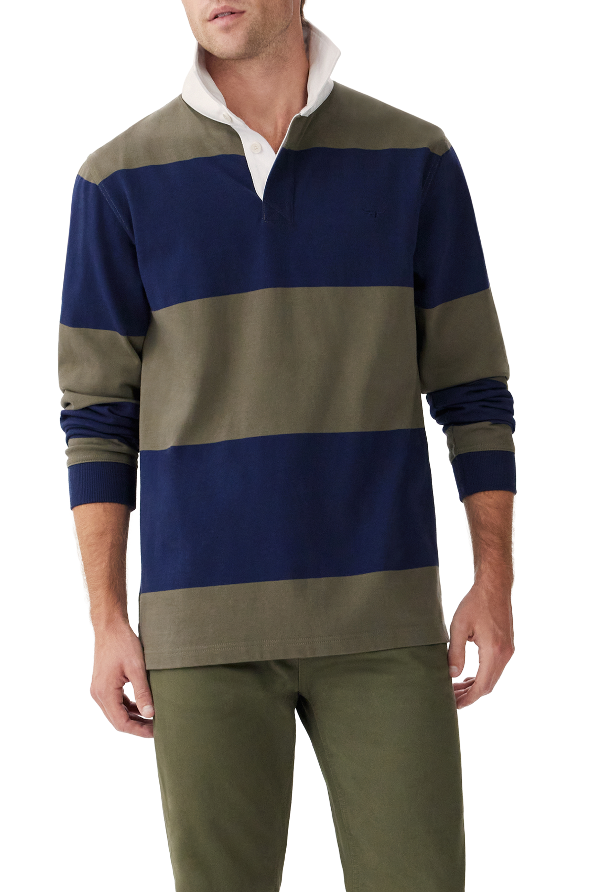 A man wears the RM Williams Tweedale Rugby, a heavyweight jersey knit long-sleeve shirt with wide navy blue and olive green stripes, white collar, button placket, classic athletic style; paired with olive green pants.