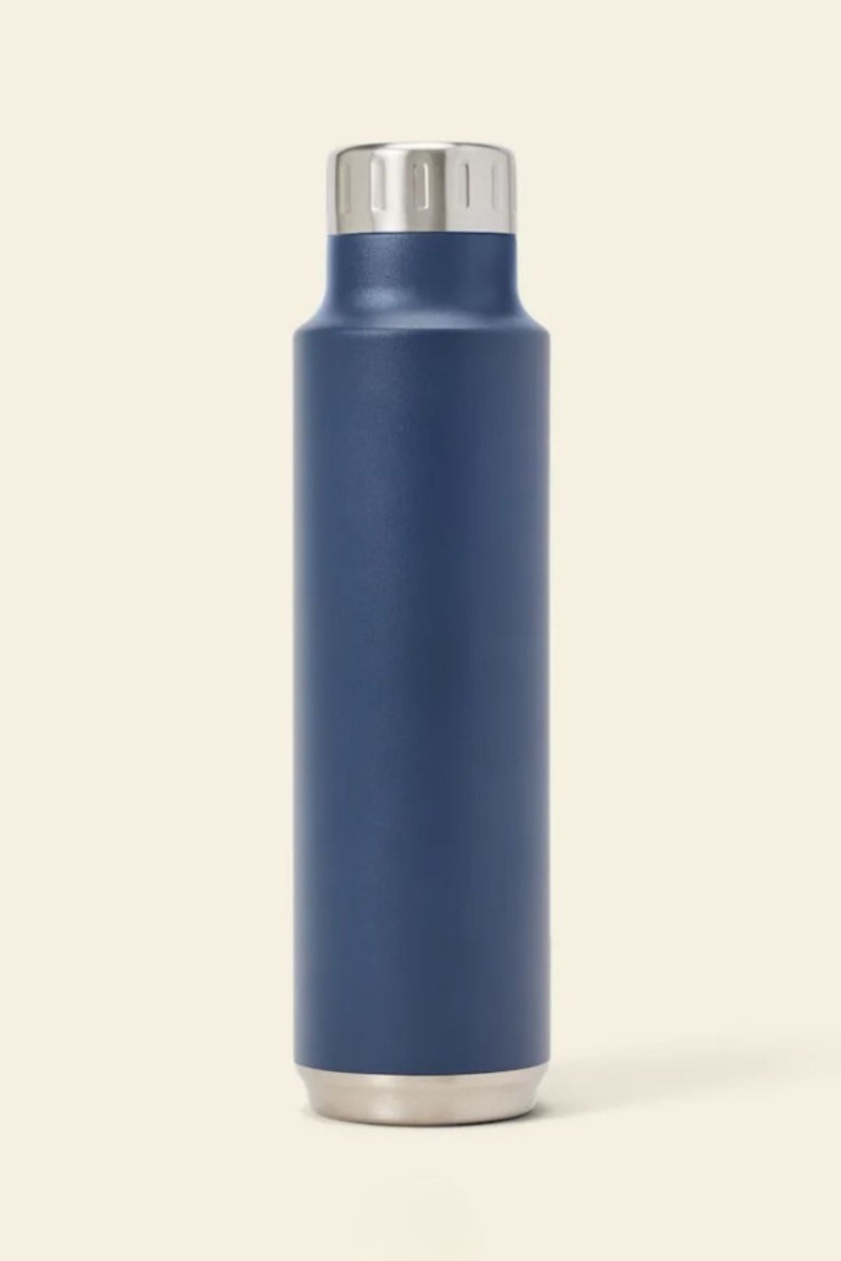 The RM Williams Water Bottle is a tall, cylindrical stainless steel flask with a matte navy blue body and metallic silver cap and base, shown upright on a plain beige background—ideal for keeping your drink at the right temperature anywhere.